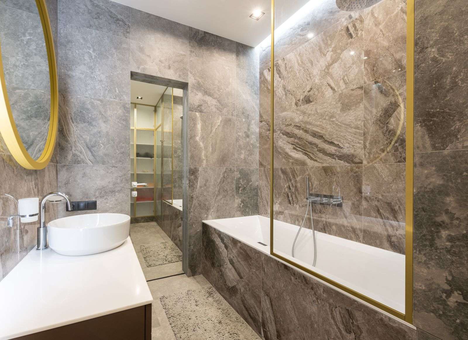 Banheiro com bancada em mármore e detalhes dourados